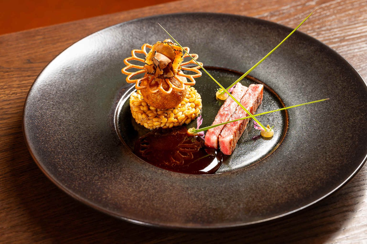 Wagyu, Einkorn-Trüffelrisotto, Einkorn-Trüffelbeignet, Marzipan-Calvadosgel, Szechuan Buttons und Klee © Claus Kadrnoschka