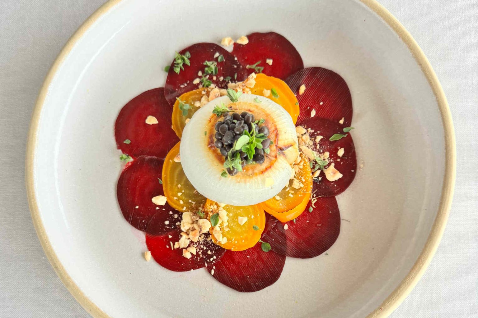 Gefüllte weiße Zwiebel auf Rote-Rübe-Carpaccio von Luger, Foto beigestellt