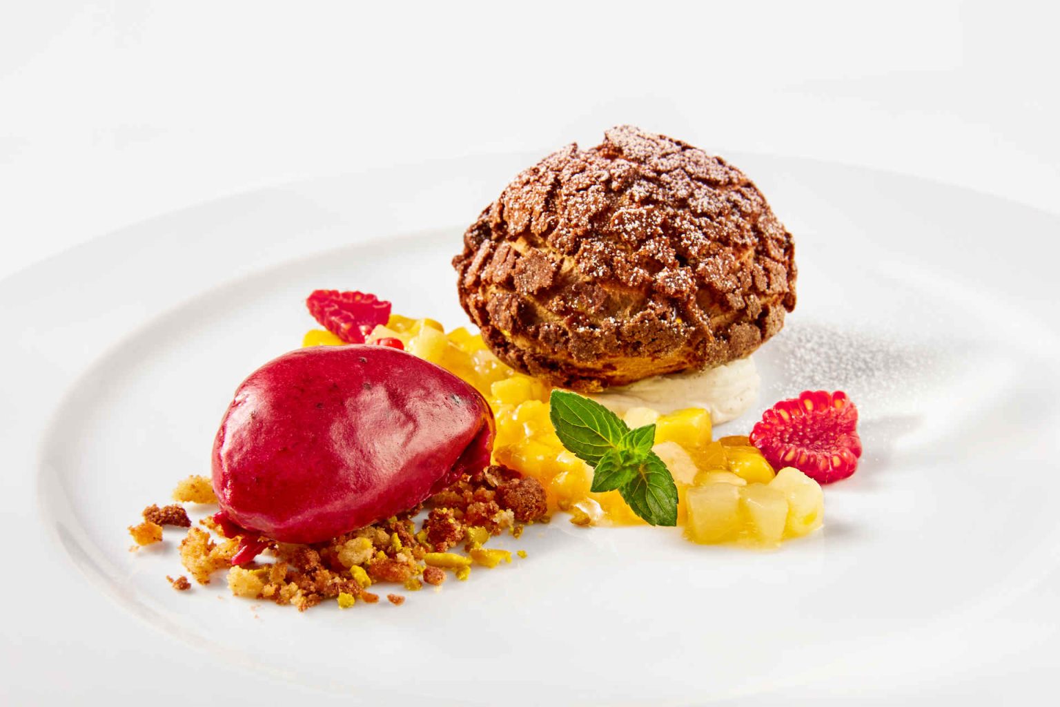 Dessert: Tonis Schokoladen-Craquelin auf Früchtecocktail, dazu Cassis-Sorbet, Foto beigestellt